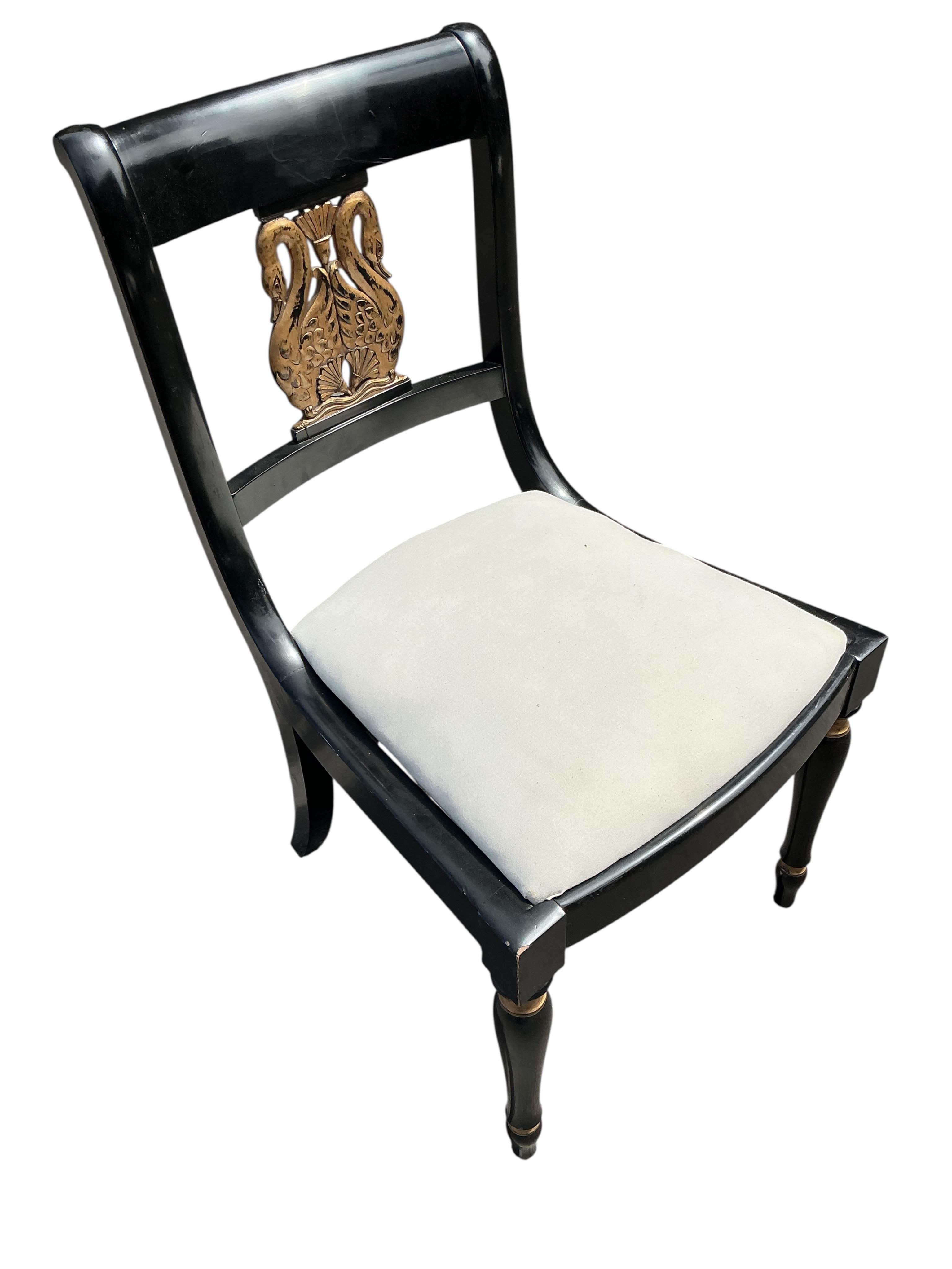 A set of six Empire style ebonised parcel gilt dining chairs, two with arms
